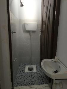 a small bathroom with a toilet and a sink at Brink Breeze Guest Rooms & Apartments in Mombasa