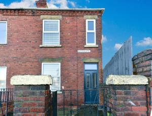 an old brick building with a blue door at 4 Bedroom, 2 bathroom house - Free Parking in Pontefract