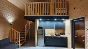 a kitchen with a refrigerator and a staircase at Piaski Rogowa in Rogowo
