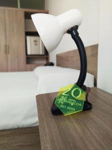 a lamp on a table with a book on it at Hotel Barbacoa Uraba in Apartadó