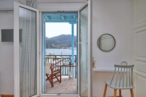 Pokój z przesuwnymi szklanymi drzwiami prowadzącymi na balkon. w obiekcie Molos House w mieście Skopelos