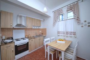 cocina con mesa y fogones horno superior en Molos House, en Skopelos Town