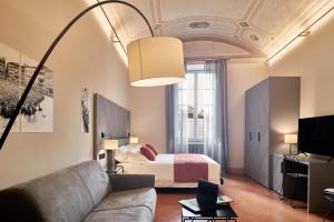 a living room with a bed and a couch at Residenza d'epoca San Martino 29 in Siena