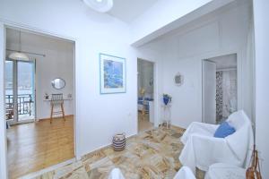 salon z białymi meblami i stołem w obiekcie Molos House w mieście Skopelos