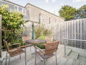 a patio with chairs and a table and a fence at Puffin Cottage in Truro