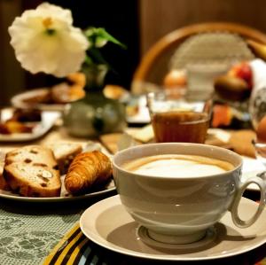 una taza de café en una mesa con pastas en Logis Saint-Flaceau, en Le Mans