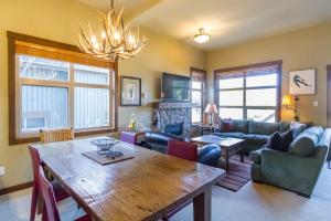 a living room with a wooden table and a couch at Ski in Ski out Minutes from Village, Private Hot Tub Sleeps 6 Free Shuttle in Whistler