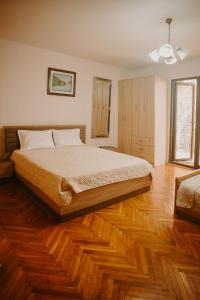 una camera con un grande letto e pavimenti in legno di Apartments Azure Adriatic a Kotor (Cattaro)