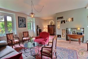 a living room with a couch and chairs and a table at La Maison Les Mimosas in Le Minihic-sur-Rance