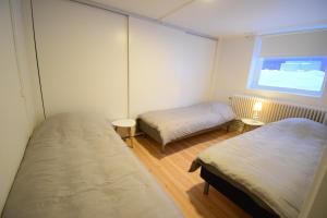 Cette petite chambre comprend 2 lits et une fenêtre. dans l'établissement Apartment in central Kiruna 7, à Kiruna