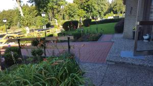 a garden with a wooden bench and flowers at Hotel Pension Fernblick in Sankt Andreasberg