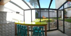 a room with a table and chairs in a greenhouse at Hormiga Negra Hostel & Café in San Carlos de Bariloche