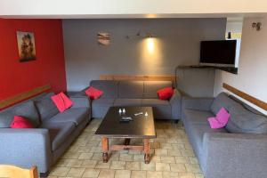 a living room with couches and a coffee table at Spacious old farmhouse with top-of-the valley view in Trois-Ponts