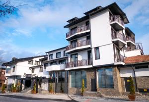 an apartment building with balconies on a street at Riverside Boutique Hotel in Bansko