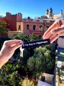 a pair of hands holding a key to happiness at Villa Nestor in Ingenio