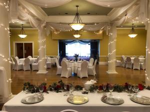 a banquet hall with white tables and chairs and lights at Stearns Hotel in Ludington