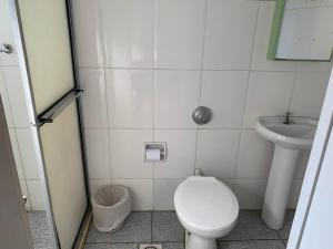 a small bathroom with a toilet and a sink at Hotel Valenciano in Valença