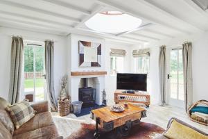 a living room with a couch a table and a fireplace at Albert Lodge in Leominster