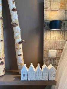 a shelf with a row of white houses next to a tree at Casa De Palmas - Tiny house in Alkmaar +75 photos