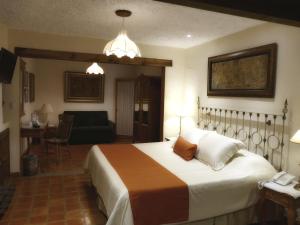 um quarto com uma cama grande e uma sala de estar em El Meson de los Poetas em Guanajuato