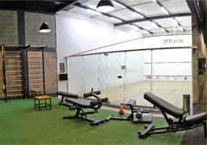 a gym with rows of exercise equipment and a basketball court at Hotel Bernal in Ituiutaba