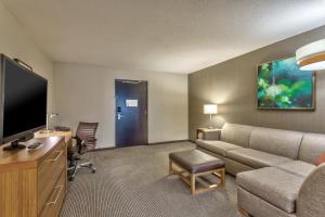 a hotel room with a couch and a flat screen tv at Hyatt Place Minneapolis/Downtown in Minneapolis