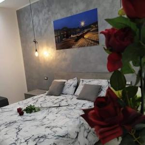 a bedroom with a white bed with flowers on it at R&B mediterraneo in Bosa