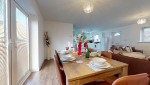 a dining room with a table with chairs and a couch at SRK Serviced Accommodation, 2 Bedroom Private Apartment, Business, Leisure, Contractors in Peterborough