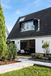 una casa blanca con techo negro en The Slow en Zuidoostbeemster