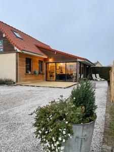 a house with a large pot of flowers in front of it at Gîtes Spa en Baie de Somme in Grand-Laviers