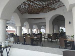 a restaurant with tables and chairs in a building at Sierra Mar All Inclusive at Tesoro Manzanillo in Manzanillo