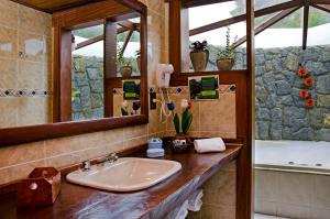 a bathroom with a sink, mirror, and tub at Hotel Bühler in Visconde De Maua