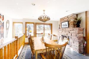 comedor con mesa y chimenea en Longs Peak Lookout Cabin, en Estes Park