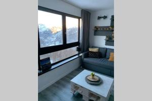 salon z kanapą i stołem w obiekcie Studio 1600 Pied des pistes avec magnifique vue w mieście Puy-Saint-Vincent