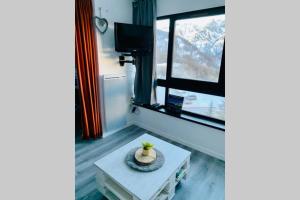 una habitación con una tarta en una mesa y una ventana en Studio 1600 Pied des pistes avec magnifique vue en Puy-Saint-Vincent