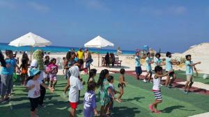 a group of children playing on the beach at شاليهات بورتو مطروح فيو بحر Porto Matrouh Sea View Families Only in Marsa Matruh
