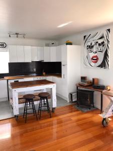 a kitchen with a table and stools in a room at Beach Front Beauty in Melbourne