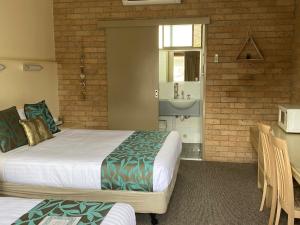 una camera d'albergo con due letti e un lavandino di Marriott Park Motel a Nowra