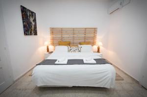 ein Schlafzimmer mit einem großen weißen Bett mit zwei Lampen in der Unterkunft LIMASSOL AKROTIRI BEACH VINE COTTAGE a in Limassol