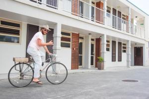 un hombre montando una bicicleta delante de un edificio en Raglan Sunset Motel and Conference Venue, en Raglan