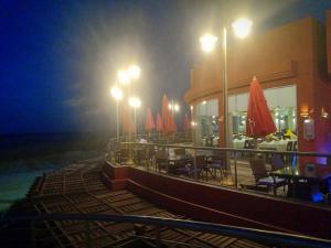 a restaurant with tables and umbrellas at night at شاليهات بورتو مطروح فيو بحر Porto Matrouh Sea View Families Only in Marsa Matruh