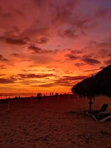 zachód słońca na plaży z ludźmi na piasku w obiekcie Grand Venetian Beachfront Condos w mieście Puerto Vallarta