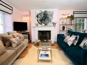 a living room with a blue couch and a fireplace at 16 Courtenay Street in Salcombe