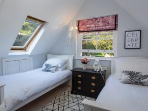 two beds in a room with two windows at 16 Courtenay Street in Salcombe