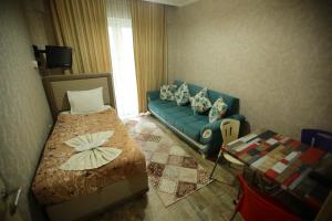 sala de estar con sofá azul y cama en Bella Suit Apart Hotel, en Isparta