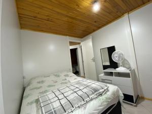 1 dormitorio con cama y techo de madera en Pousada da Z, en Urubici