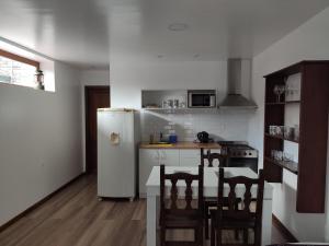 a kitchen with a white refrigerator and a table and chairs at La MagnoliaII in Mar del Plata