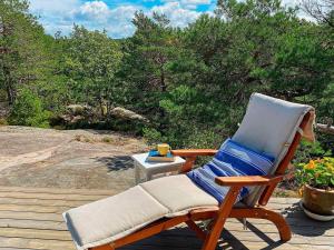 a rocking chair sitting on a deck with a table at 9 person holiday home in Vester y in Hauge