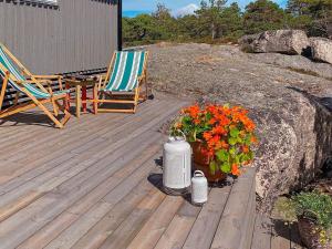 a deck with a chair and a heater and flowers at 9 person holiday home in Vester y in Hauge