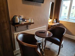 a room with two chairs and a small table at The Penkelie in Southport